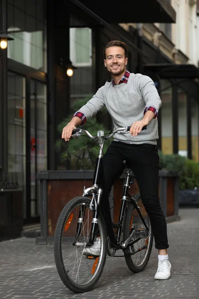 Guapo feliz hombre a caballo bicicleta en la calle de la ciudad — Foto de Stock