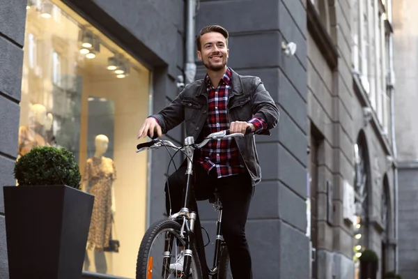 Hezký šťastný muž na kole na ulici města — Stock fotografie