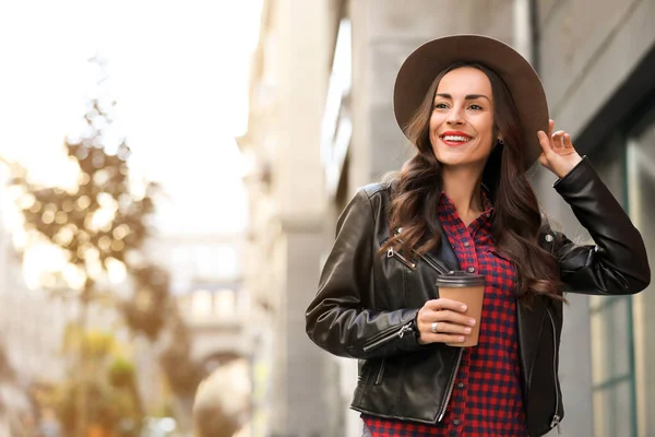 Hermosa mujer con taza de café en la calle de la ciudad. Caminata de otoño — Foto de Stock