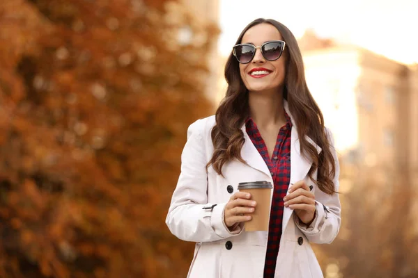 Hermosa mujer con taza de café en la calle de la ciudad. Caminata de otoño — Foto de Stock