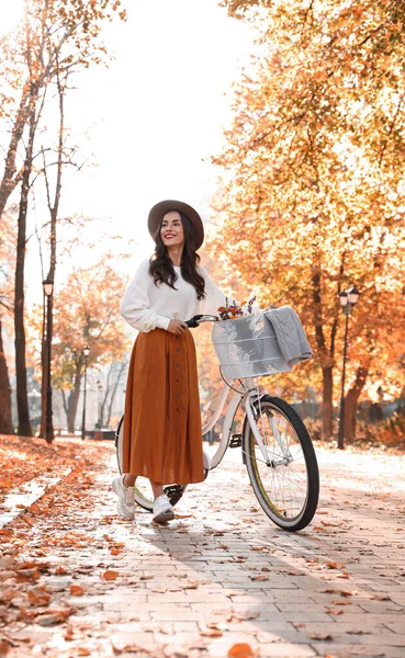 Beautiful happy woman with bicycle in autumn park — Zdjęcie stockowe