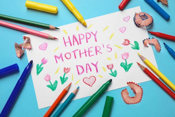 Composición laica plana con tarjeta de felicitación hecha a mano para el Día de la Madre sobre fondo azul — Foto de Stock