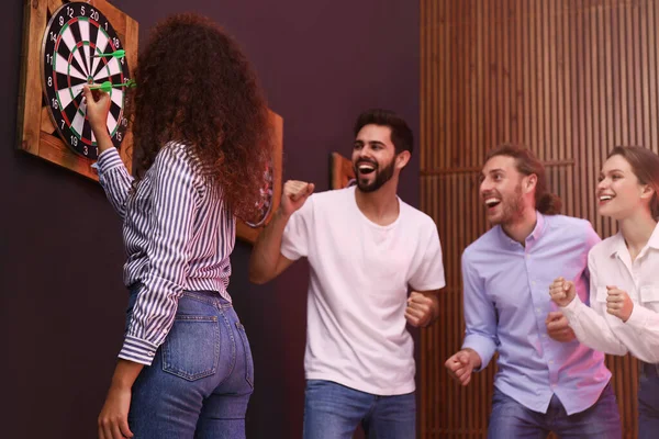 Grupo de amigos jogando dardos no bar — Fotografia de Stock