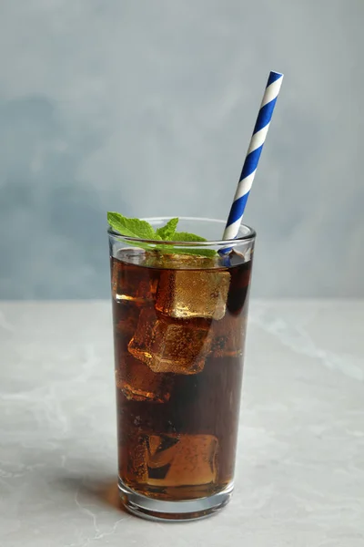 Menyegarkan minuman soda dengan jerami di meja abu-abu dengan latar belakang biru — Stok Foto