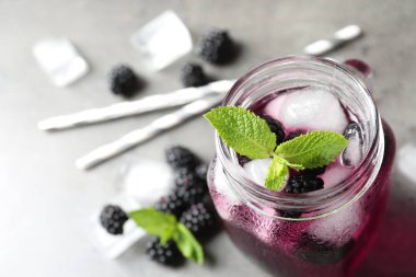 Işık masasında nefis, ferahlatıcı böğürtlen limonatası, yakın plan.