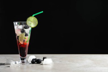 Masanın üzerinde koyu arkaplanda lezzetli, ferahlatıcı böğürtlen limonatası. Metin için boşluk