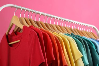 Pembe arka planda parlak giysiler. Gökkuşağı renkleri