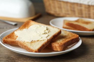 Tahta masada tereyağlı kızarmış ekmek, yakın plan.