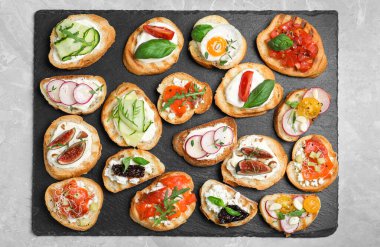 Açık gri mermer masa üzerinde farklı bruschettalar.