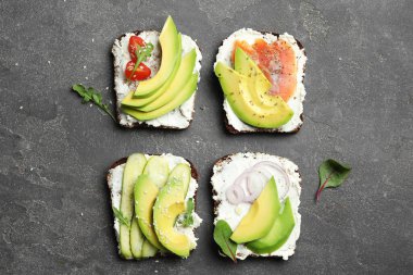 Koyu masada nefis avokado sandviçleri.