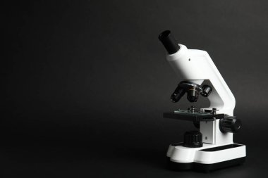 Siyah zemin üzerine modern mikroskop, metin için boşluk. Tıbbi ekipman