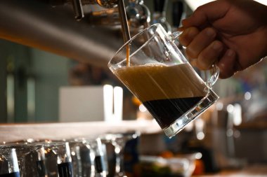 Barmen barda bardağa bira dolduruyor.