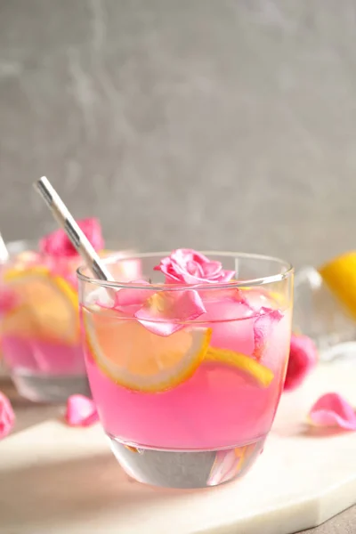 Glass of refreshing drink with lemon and roses on marble table — Stock Photo, Image
