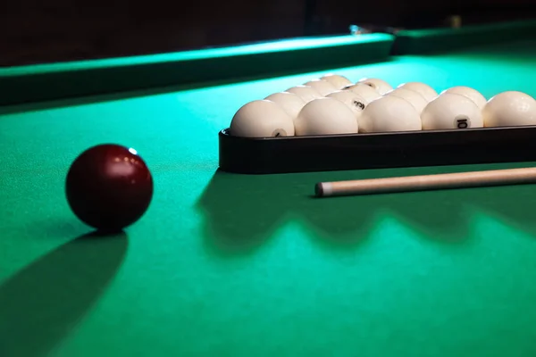 Billiard balls, triangle rack and cue on table