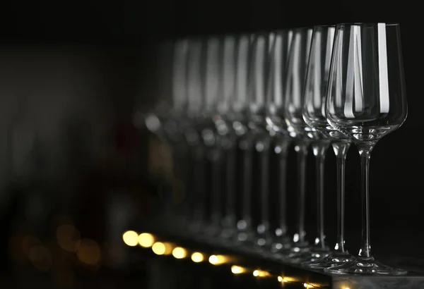 Lege schone glazen op tafel tegen donkere achtergrond. Ruimte voor tekst — Stockfoto