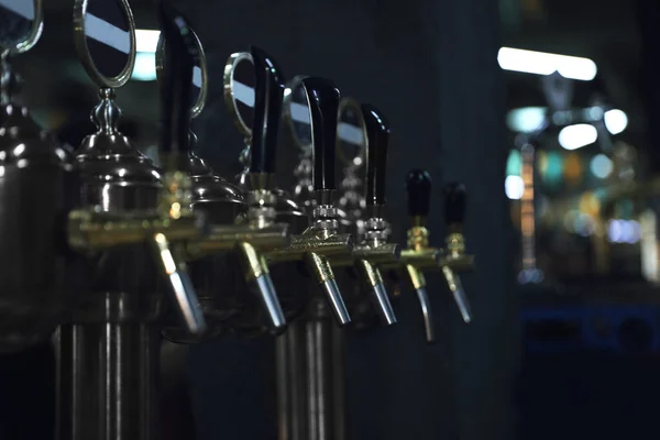 New modern beer taps on bar counter in pub — Stock Photo, Image