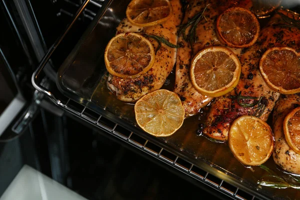Baking dish with delicious lemon chicken in oven, closeup view — Stock Photo, Image