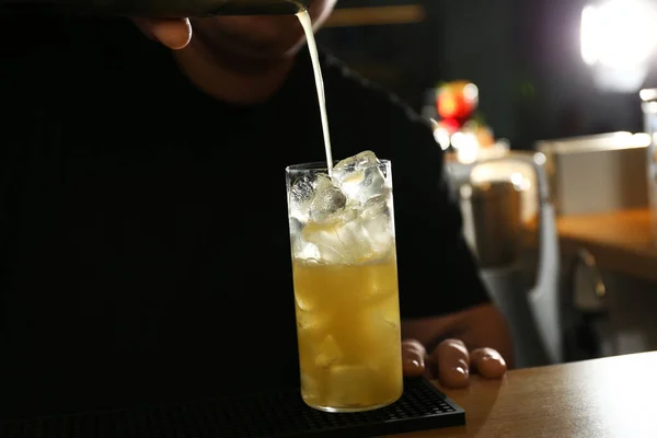 Bartender gör läckra cocktail med vodka vid träbänk i baren, närbild — Stockfoto