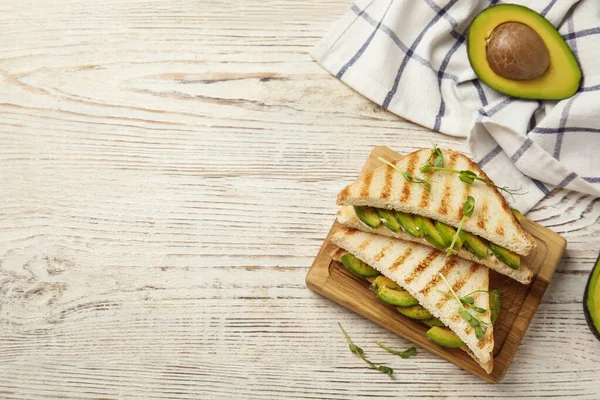 Platte lay compositie met avocado sandwiches op witte houten tafel. Ruimte voor tekst — Stockfoto