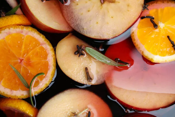 Tasty mulled wine with spices as background, closeup — Stock Photo, Image