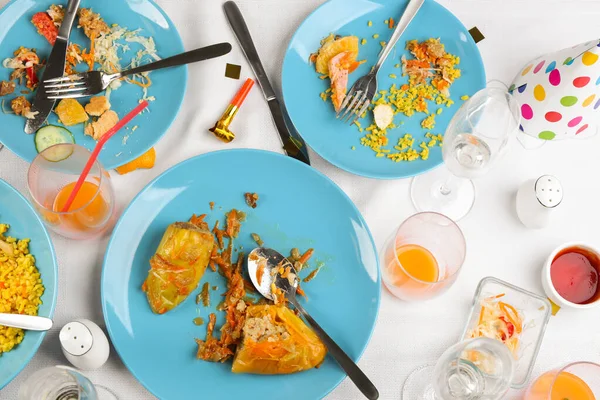Platte lay compositie met etensresten op wit tafelkleed na feest — Stockfoto