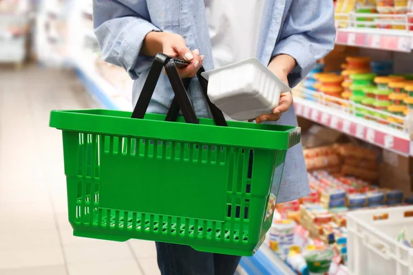 Женщина с корзиной в супермаркете, крупный план — стоковое фото