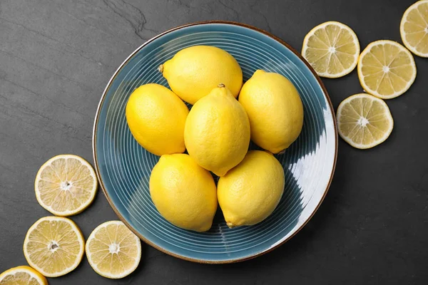 Composition plate avec des citrons frais et mûrs sur table noire — Photo