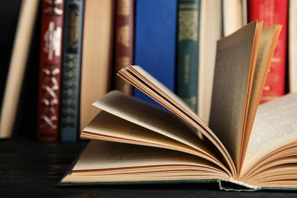 Abrir livro capa dura em mesa de madeira preta, close-up — Fotografia de Stock