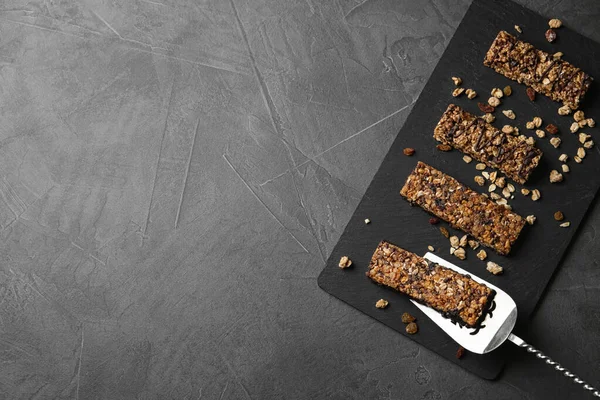 Slate board with healthy granola bars on grey table, top view. Space for text — Stock Photo, Image