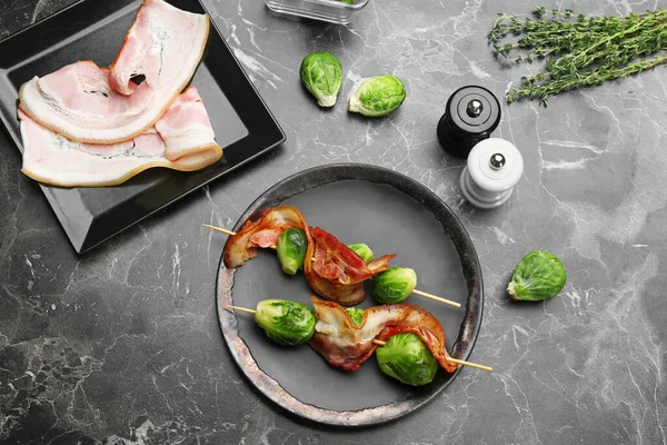 Ζύμες με λαχανάκια Βρυξελλών και μπέικον σερβιρισμένες σε μαρμάρινο τραπέζι, επίπεδες στρώσεις — Φωτογραφία Αρχείου