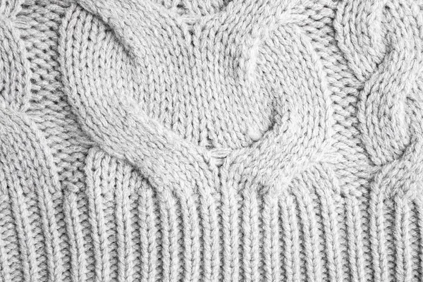 Grey knitted sweater as background, closeup view