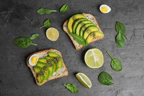 Platte lay compositie met avocado toastjes op zwarte tafel — Stockfoto