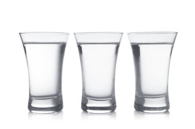 Beyaz arka planda shot bardaklarında soğuk votka