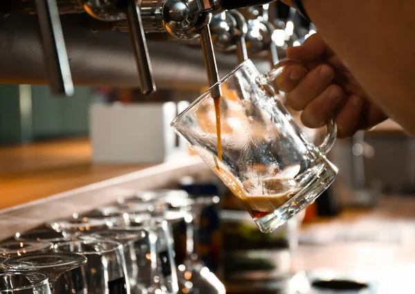 Bartendern häller öl i glas på puben, närbild — Stockfoto