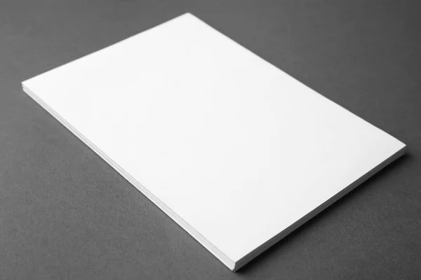 Hojas de papel en blanco sobre fondo gris oscuro, primer plano. Prepárate para el diseño —  Fotos de Stock