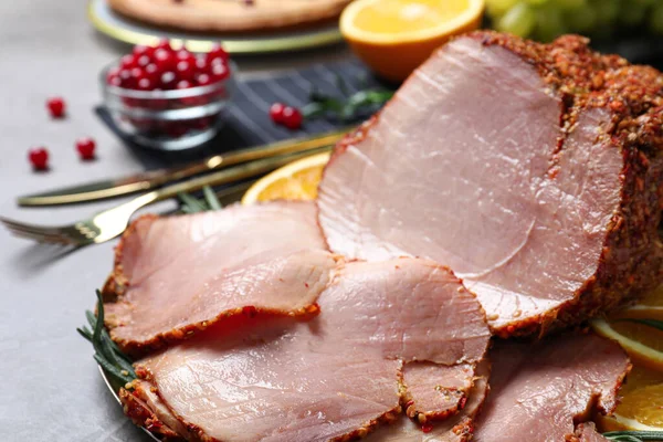 Lezzetli jambon, şenlikli bir akşam yemeği için gri masada, yakın plan.