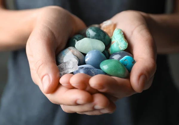 Mulher segurando pilha de pedras preciosas diferentes, close-up — Fotografia de Stock