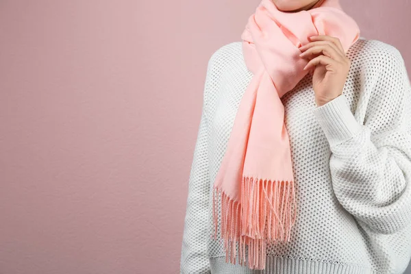 Woman wearing warm scarf on pink background, closeup with space for text. Autumn clothes — Stock fotografie