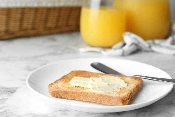Kromka tostowego chleba z masłem na białym marmurowym stole — Zdjęcie stockowe