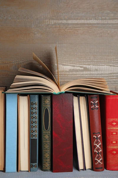 Verschillende hardcover boeken op grijze houten tafel — Stockfoto