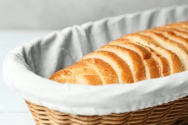 Skivor bröd i korg på vitt bord, närbild — Stockfoto