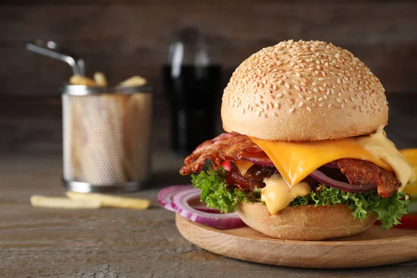 Skład z soczystym burgerem bekonowym na drewnianym stole. Miejsce na tekst — Zdjęcie stockowe