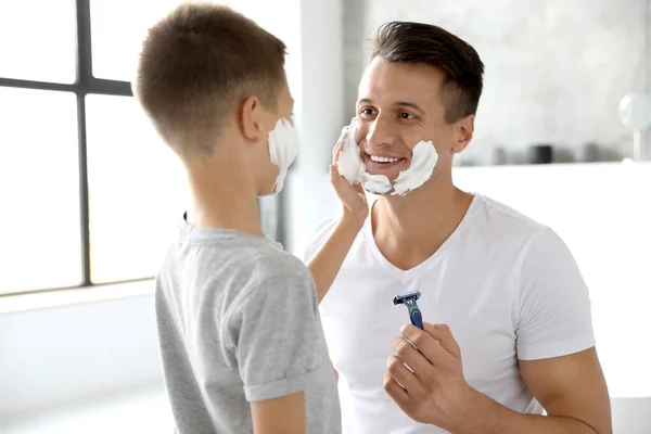 Filho Aplicando Espuma Barbear Rosto Pai Banheiro — Fotografia de Stock