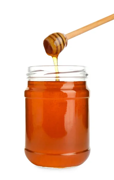 Glass jar of wildflower honey and wooden dipper isolated on whit — Stock Photo, Image