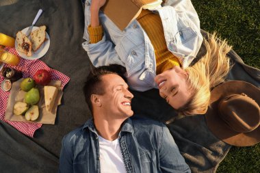 Mutlu genç çift güneşli bir günde piknik yaparken dinleniyor.