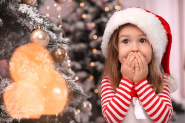 Evde Noel ağacının yanında şaşırmış bir çocuk var. Metin için boşluk