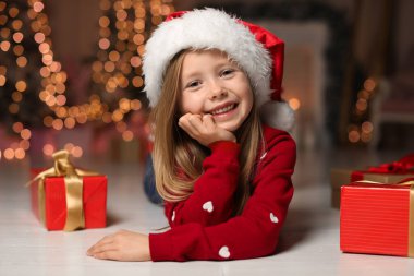 Cute little child with Christmas gifts at home