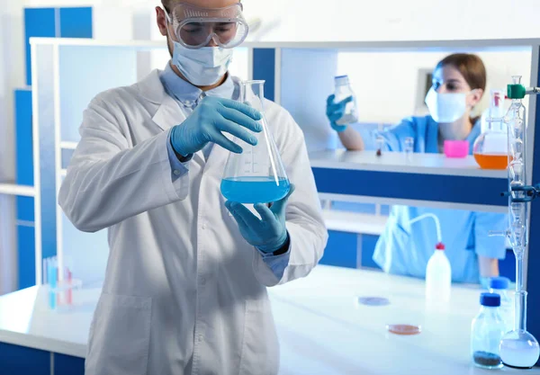 Cientista Segurando Frasco Cônico Com Líquido Azul Dentro Casa Análise — Fotografia de Stock