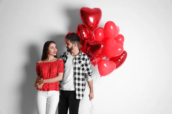 Happy Young Couple Heart Shaped Balloons Light Background Valentine Day — Stock Photo, Image