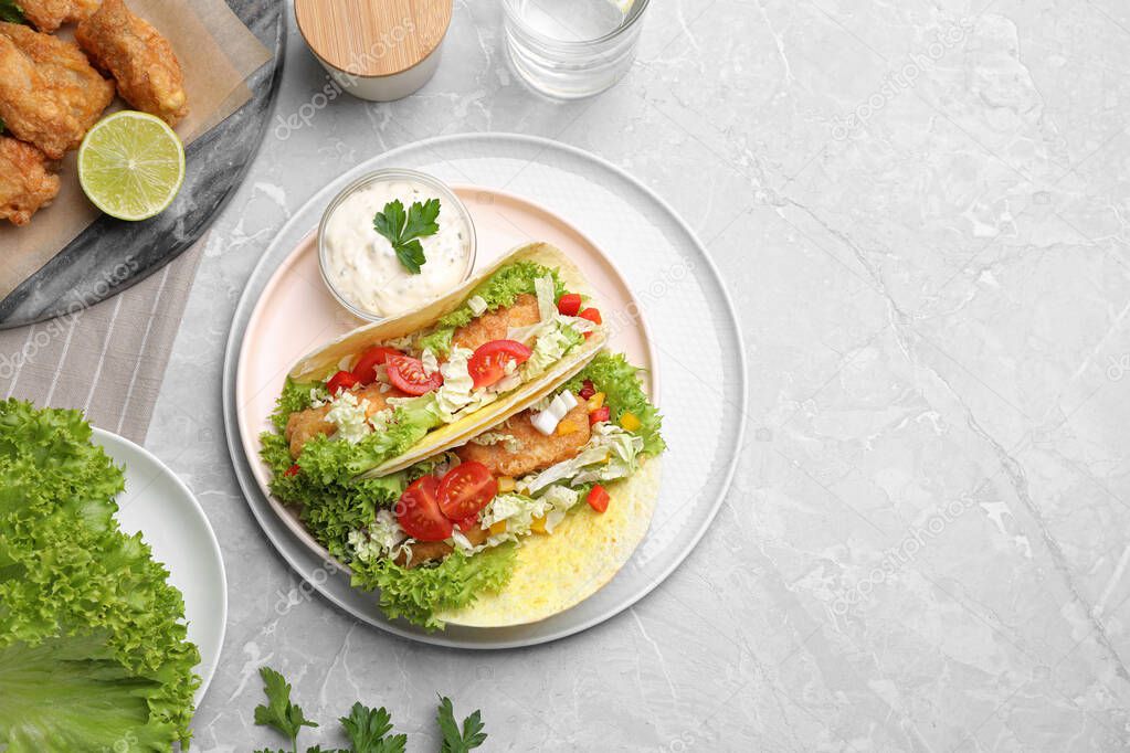 Delicious fish tacos served on grey marble table, flat lay with space for text